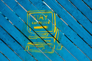 黃色塗鴉畫，畫有一部電腦，藍色木條上寫有「STAY connected」。