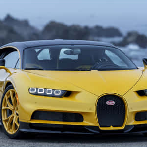 黃色Bugatti跑車停泊在海洋旁，後面有岩石峭壁。