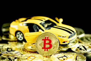 黃色玩具車被金色比特幣硬幣包圍。