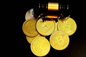 一堆金色加密貨幣硬幣，上面有槌子。