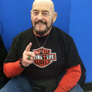 光頭留鬍的男人微笑指向鏡頭，身穿Harley T恤。 — 摔角 GIF 壁紙