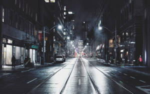 雨夜的城市街道，閃爍的路燈和遠處的車流。