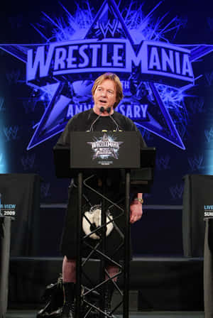 穿著蘇格蘭裙的男子在WrestleMania記者會講台上發言。