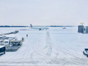 白雪覆蓋的機場停機坪，停泊著飛機和地面設備。