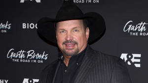 Garth Brooks 在宣傳活動中戴著黑色牛仔帽和西裝。