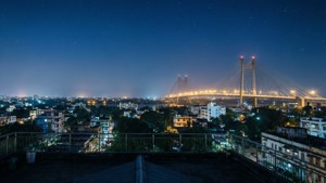 屋頂夜景，顯示照亮橋樑橫跨河流，城市燈光和星空