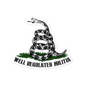 盤繞的響尾蛇貼紙，帶有文字 well regulated militia，在草地上。