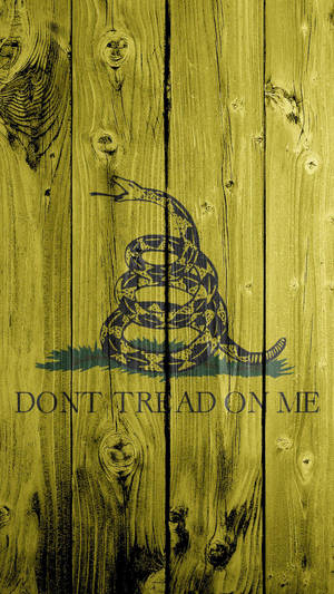 盤繞的響尾蛇，上面有'DON'T TREAD ON ME'繪在木板上。