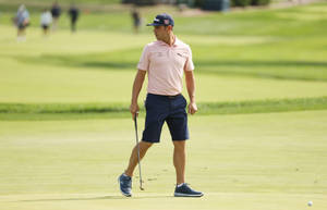 高爾夫球手在綠色高爾夫球場上行走，手持推桿 — 4K 高爾夫球場 壁紙
