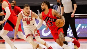 多倫多速龍球員在NBA比賽中運球越過芝加哥公牛防守球員。