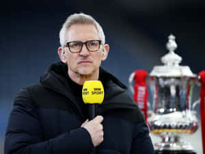 穿黑色外套的男子在銀色獎盃旁拿著BBC Sport咪高峰。 — 足球 壁紙