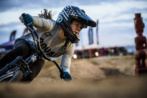 女BMX車手在泥地賽道上傾身過彎。