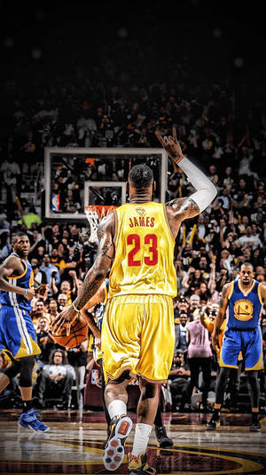 勒邦占士在NBA比賽中身穿黃色球衣運球，觀眾歡呼。