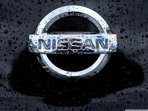 黑色表面上帶有雨滴的日產汽車標誌。
