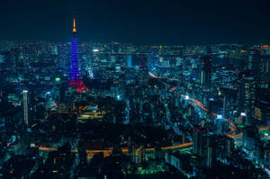 夜晚的東京城市景觀，有發光的東京塔和明亮的街道。