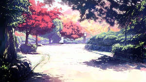 一條蜿蜒小徑穿過公園，公園裡有色彩繽紛的樹木，上方是閃耀的日落。 — 美學電腦 壁紙