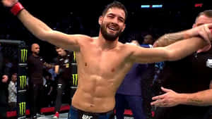 UFC拳手在八角籠中高舉雙臂慶祝勝利。