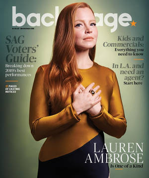 女演員 Lauren Ambrose 在 Backstage 雜誌封面上，身穿金色上衣，雙手放在心口。