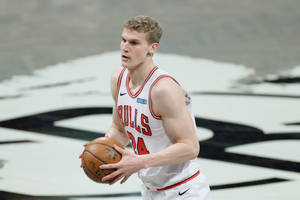 身穿公牛隊球衣的籃球運動員在比賽中運球。