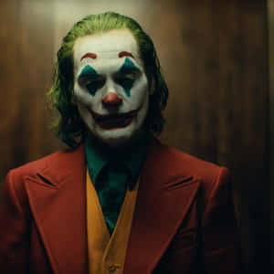 一個帶有綠色頭髮和紅色西裝的威脅性小丑，對著昏暗的木牆強烈凝視。