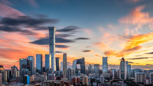 現代城市天際線在日落時分，色彩繽紛的雲彩和玻璃塔。 — 中國 壁紙