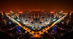 充滿活力的城市夜間航拍，建築物燈火通明，車輛移動形成光跡。 — 唐人街 GIF 壁紙