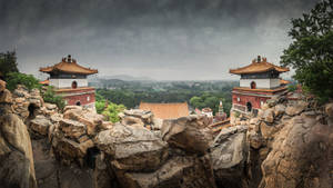 岩石懸崖上的寺廟建築，俯瞰著暴風雨天空下的迷霧山谷。