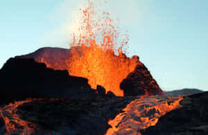 火山爆發，明亮的橙色熔岩映襯著暗藍色的天空。