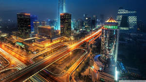 夜間城市景觀，燈火通明的建築物和車輛光跡。