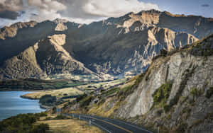 懸崖邊蜿蜒的道路，俯瞰湖泊和背景山脈