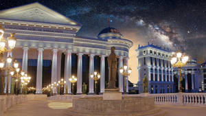 古典博物館建築在夜晚星空下亮起燈光，銀河清晰可見。 — 夜空 壁紙