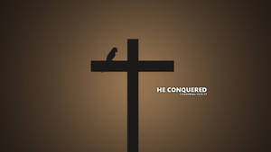 黑色十字架上有鳥棲息，棕色漸變背景上寫有「HE CONQUERED」文字