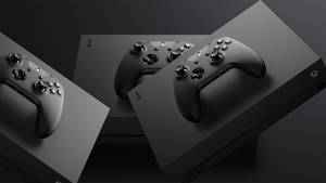 在黑暗的攝影棚環境中，三個黑色Xbox控制器放在主機盒上。