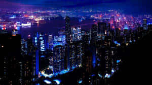 一個充滿活力的夜景，有發光的摩天大樓和海濱。 — 夜晚 GIF 壁紙