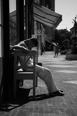 一個男人在陽光普照的人行道的椅子上睡覺。 — 美學 壁紙