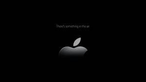 Apple標誌帶有文字There's something in the air在黑色背景上