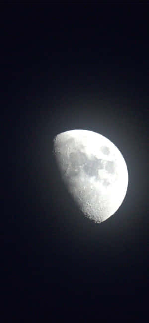 在黑暗的夜空中，一輪明亮的彎月帶有可見的隕石坑。