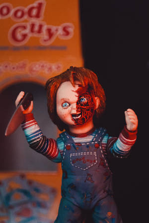 半邊臉融化的恐怖娃娃在昏暗燈光下拿著刀。