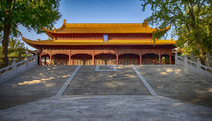 宏偉的傳統中式寺廟，金色屋頂和石階，藍天之下 — 花城 壁紙