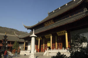 遊客在擁有曲線屋頂和紅色柱子的傳統中式寺廟附近走動。 — 唐人街 GIF 壁紙