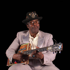 穿西裝戴帽子的男子在錄音室彈奏訂製結他 — 音樂 GIF 壁紙
