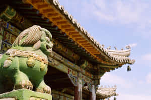 藍天下傳統中式寺廟前的綠色石獅守護雕像