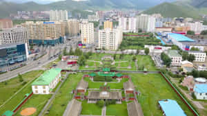 從高空俯瞰城市，現代建築與被綠意環繞的傳統寺廟。