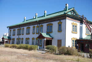 歷史悠久的白色建築，帶金色裝飾和綠色屋頂，陽光明媚