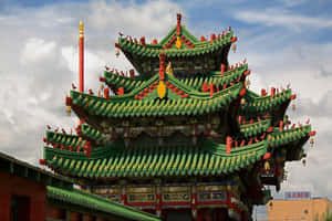 在多雲的天空下，一座色彩鮮豔的綠紅傳統中式寺廟，屋頂細節華麗。