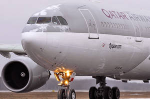 卡塔爾航空飛機在積雪跑道上，起落架燈閃爍。 — 飛機 壁紙