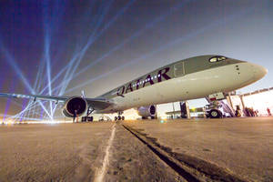 一架卡塔爾航空飛機在夜間機場停機坪上被藍色聚光燈照亮。 — 夜晚 GIF 壁紙