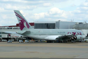 卡塔爾航空A380飛機停泊在機場閘口，旁邊有地勤車輛。