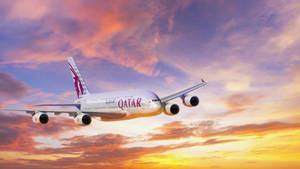 卡塔爾航空A380在色彩繽紛的夕陽天空下飛行。