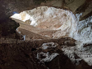 洞穴內的古老石頭遺跡，陽光從上方開口照射進來。 — Cavetown 壁紙